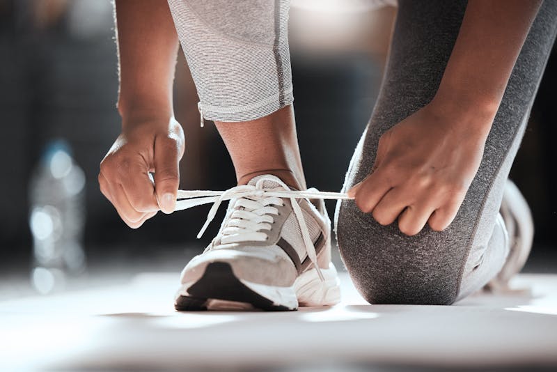 Vrouw die sportschoen strikt