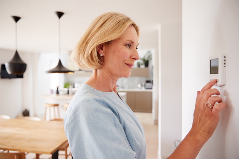 vrouw past thermostaat aan