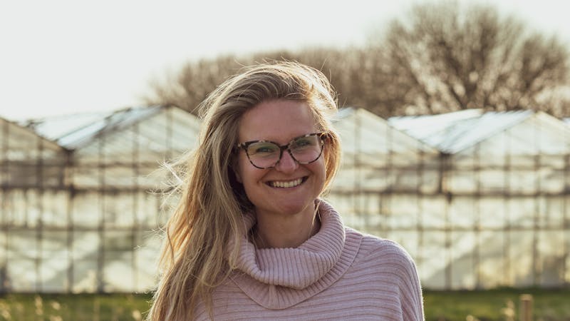 Vrouw met blond haar en bril op lacht