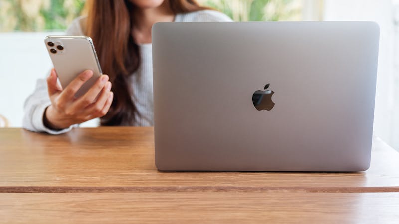 MacBook iPhone vrouw bureau werken