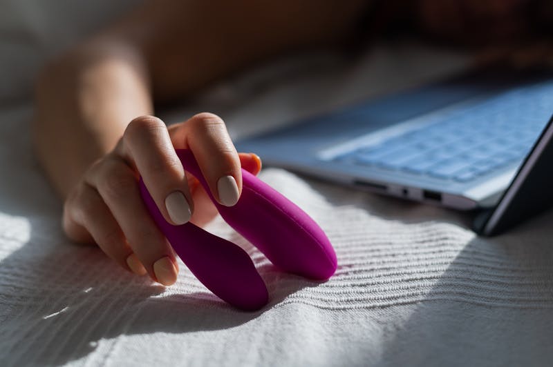 Vrouw met een u-vormige vibrator in haar hand.