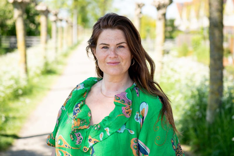 Vrouw in tuin met groene blouse aan