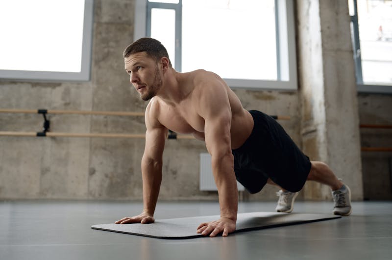 Man die push ups doet in sportschool