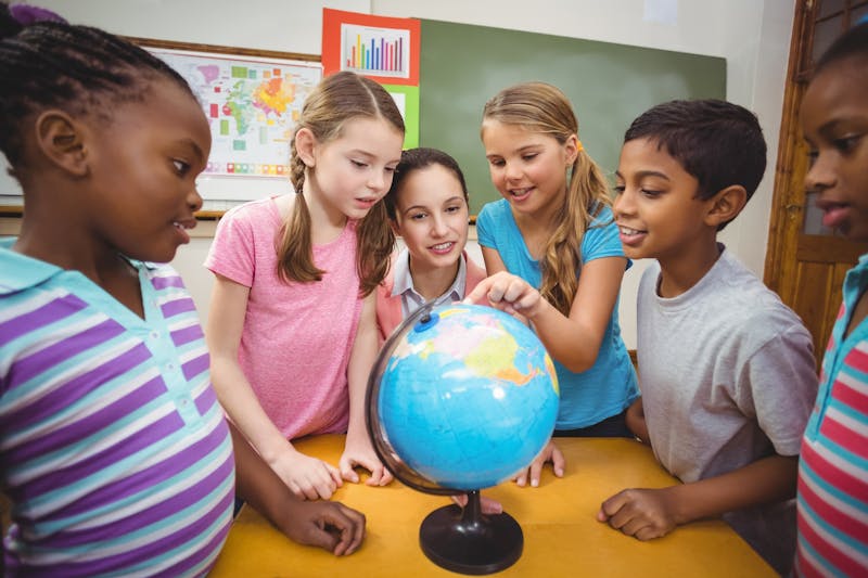 Kinderen in de klas bij een wereldbol