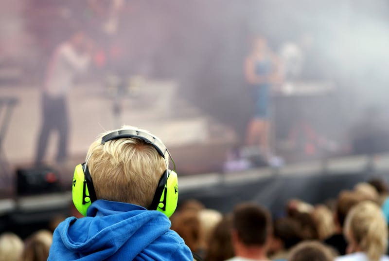 Jongen met koptelefoon bij een concert