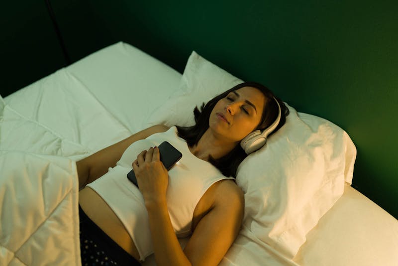 Vrouw die in bed slaapt met headset op