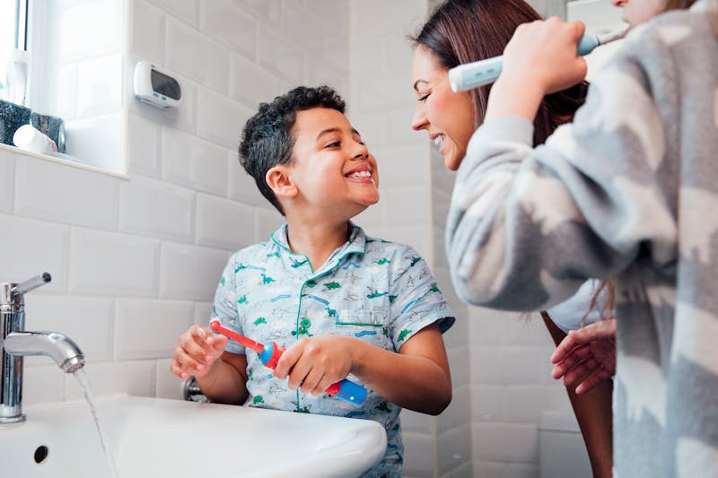 Een moeder controleert of haar zoon goed zijn tanden heeft gepoetst