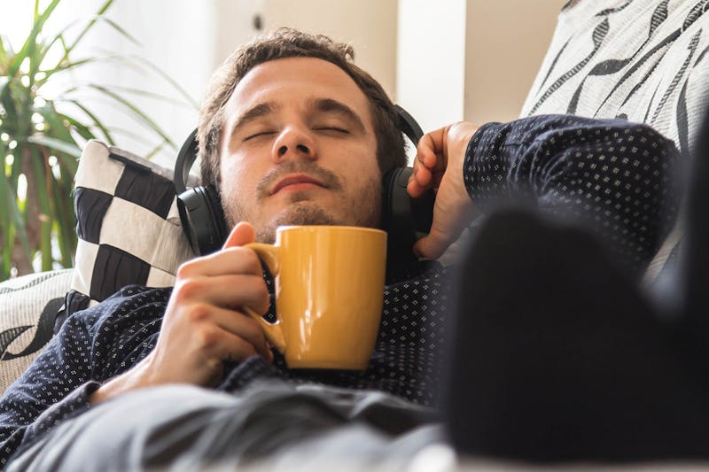 Man met koptelefoon en koffie