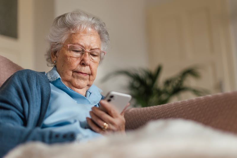 Oudere dame kijkt op haar smartphone