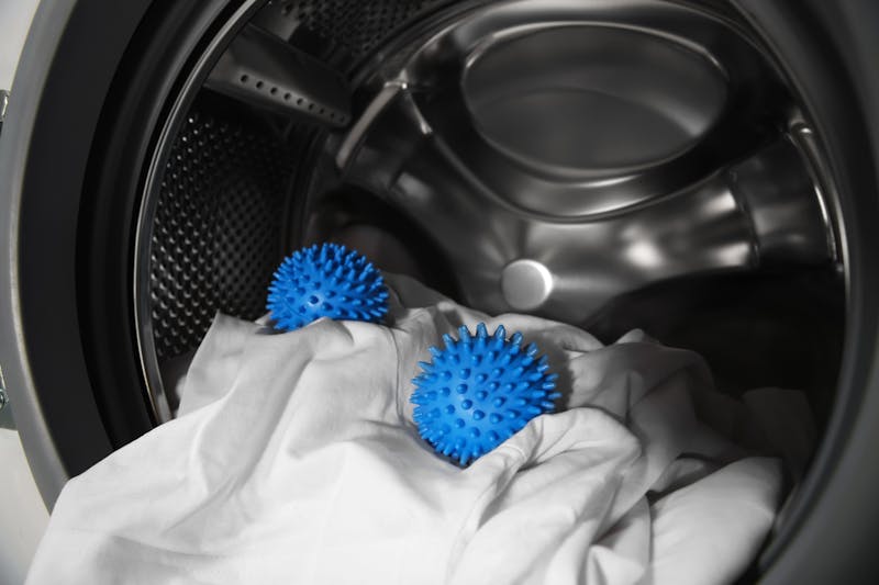 Blauwe wasballen in een wasmachine trommel