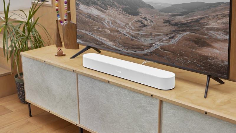 Een witte Sonos Beam bij een tv.