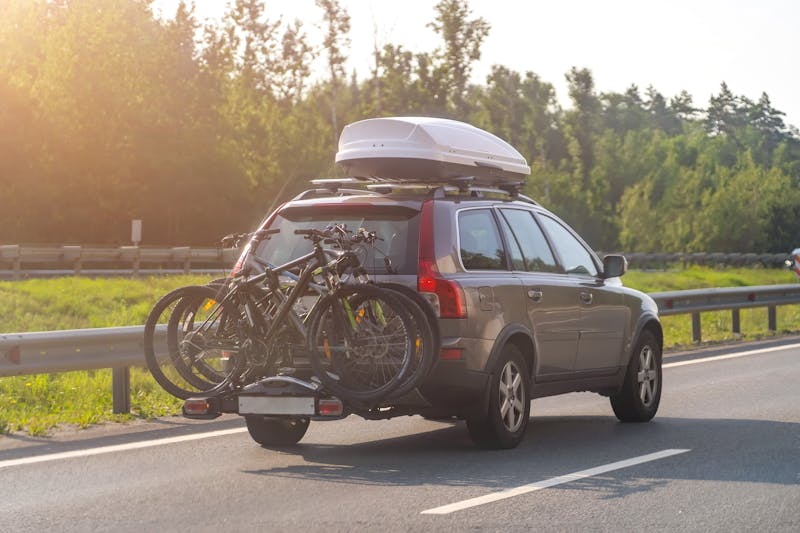 Auto met fietsendrager, fietsen en dakkoffer