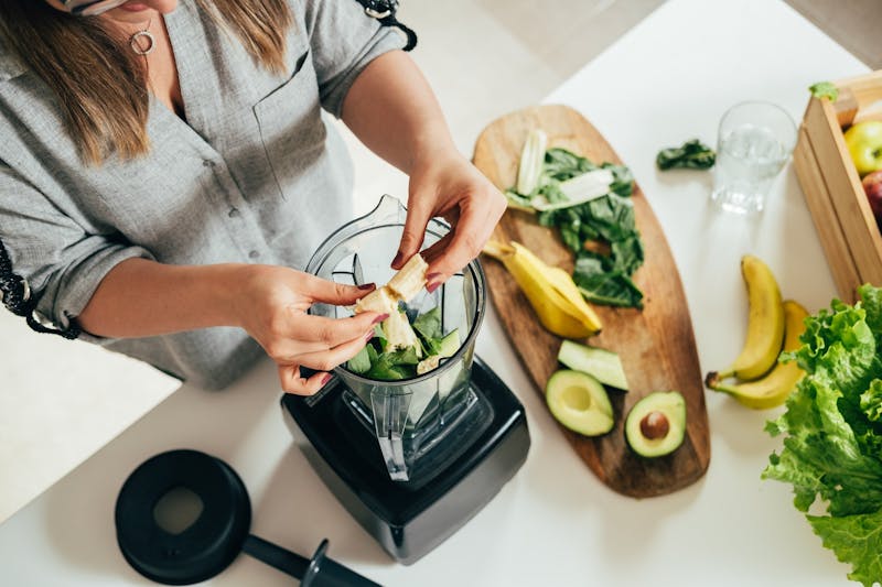 Vrouw maakt smoothies in een blender