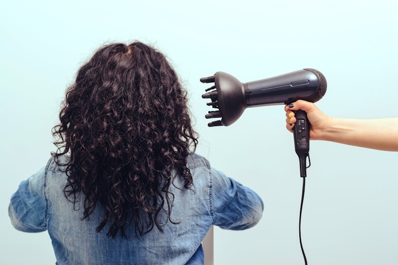 Vrouw met föhn en diffuser