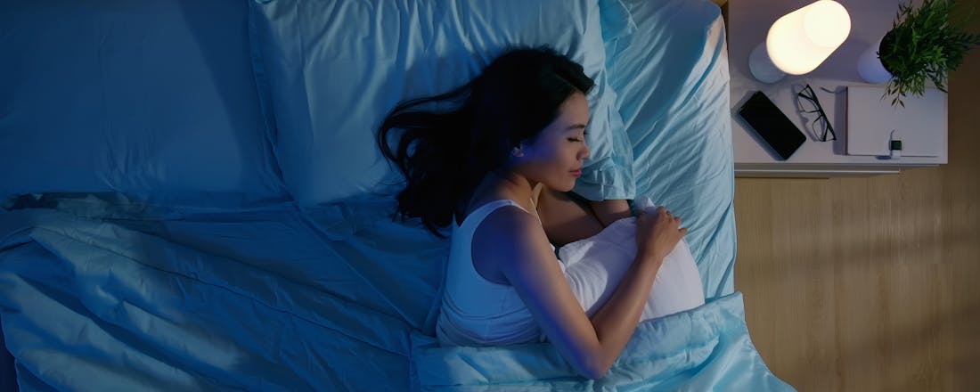 vrouw slapen bed slaap smartphone Stressvrij slapen: gebruik deze apps!