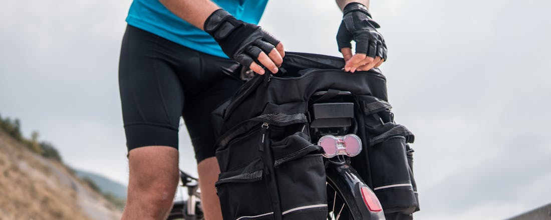 Man met fiets en fietstassen Hoe kies je de ideale fietstas?
