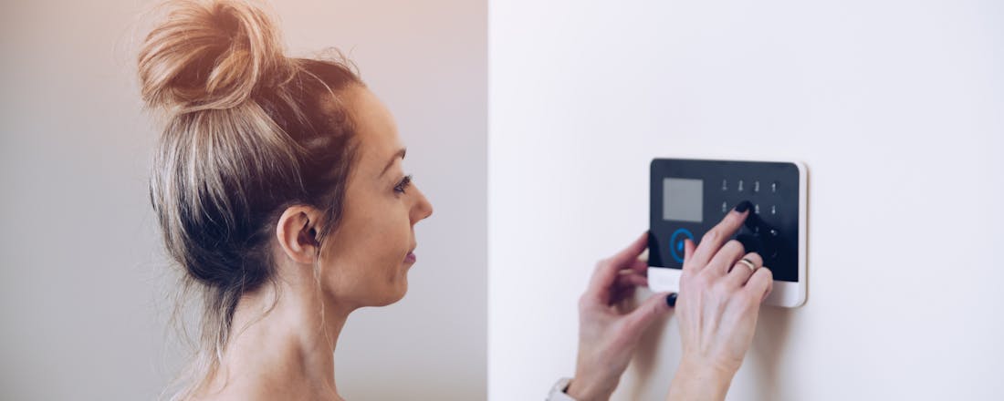Vrouw die code van alarmsysteem invoert. Zo kies je het beste alarmsysteem om je huis te beveiligen