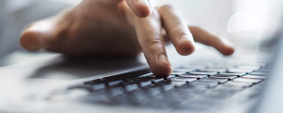 Hand van man op toetsenbord Zo beheer je een pc op afstand met een netwerk-KVM