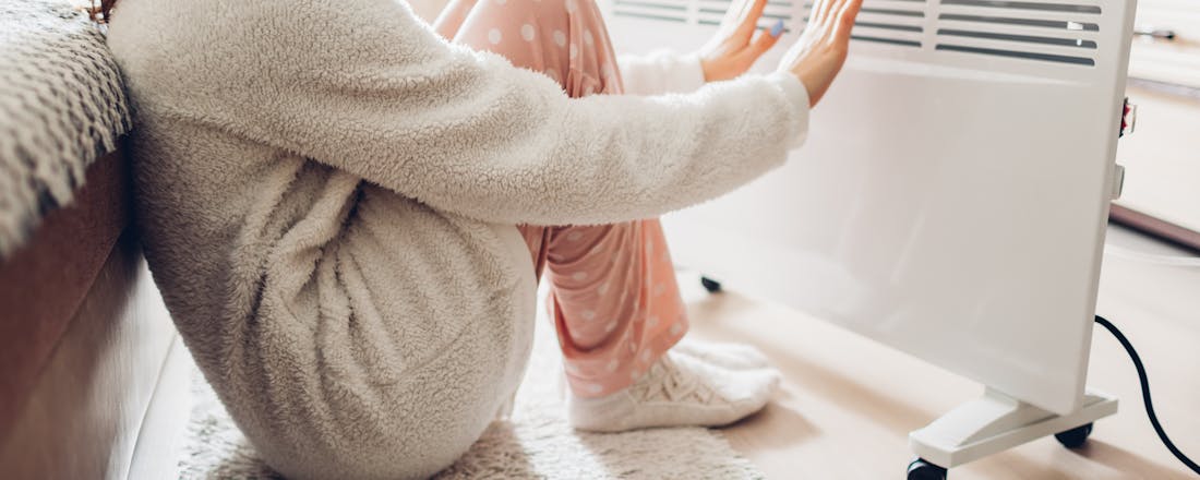 Vrouw bij kacheltje Dit zijn de 5 beste deals voor elektrische kachels van dit moment