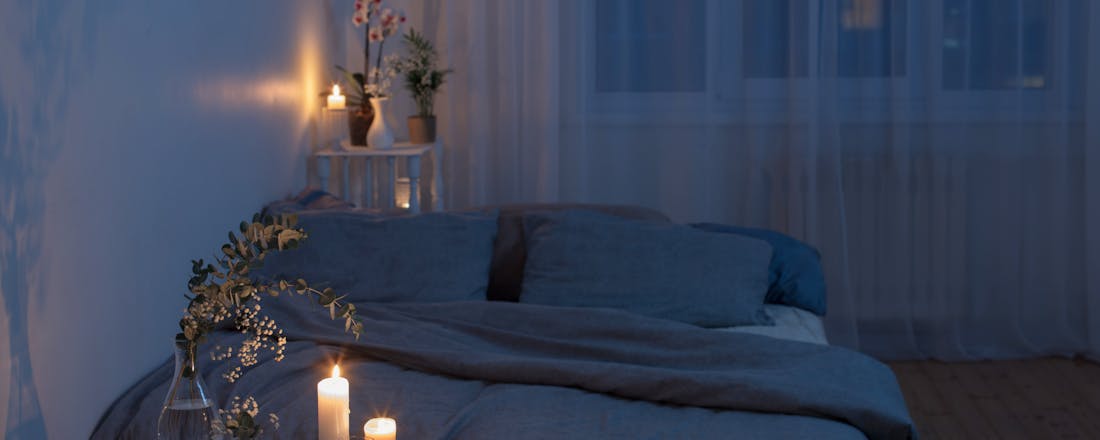 Slaapkamer met kaarslicht en intieme sfeer Seksuele meditatie: wat is het en waarom zou je het doen?