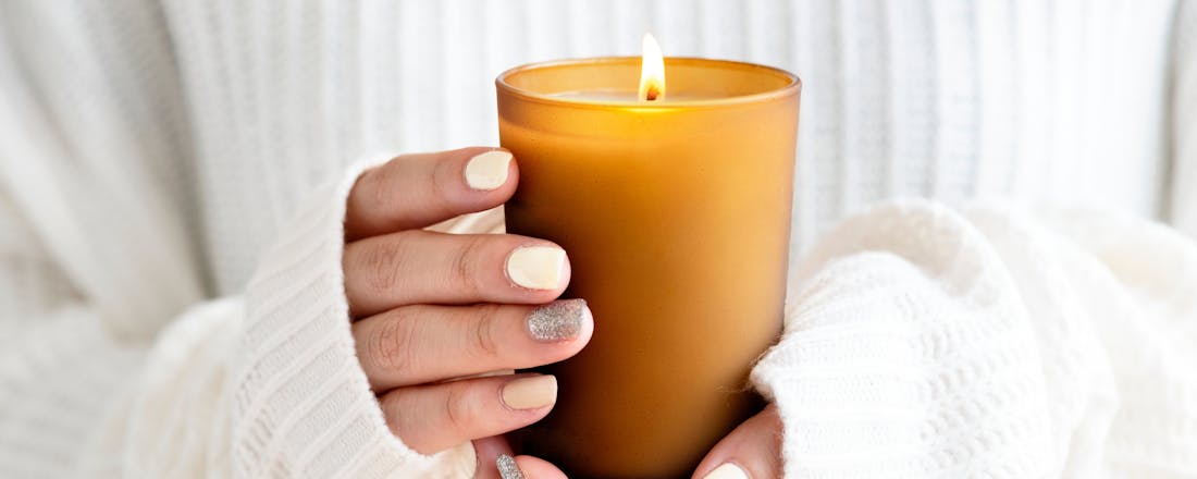 Vrouw die kaars vasthoudt De kaars als sfeermaker ... én ook als warmtebron?