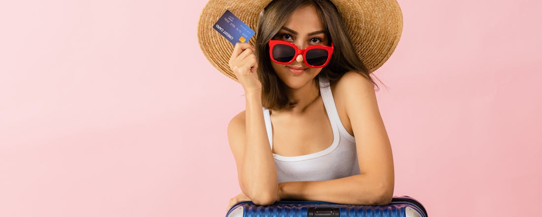 Vrouw met koffer en creditcard Wat heb je aan de reisverzekering op je creditcard?