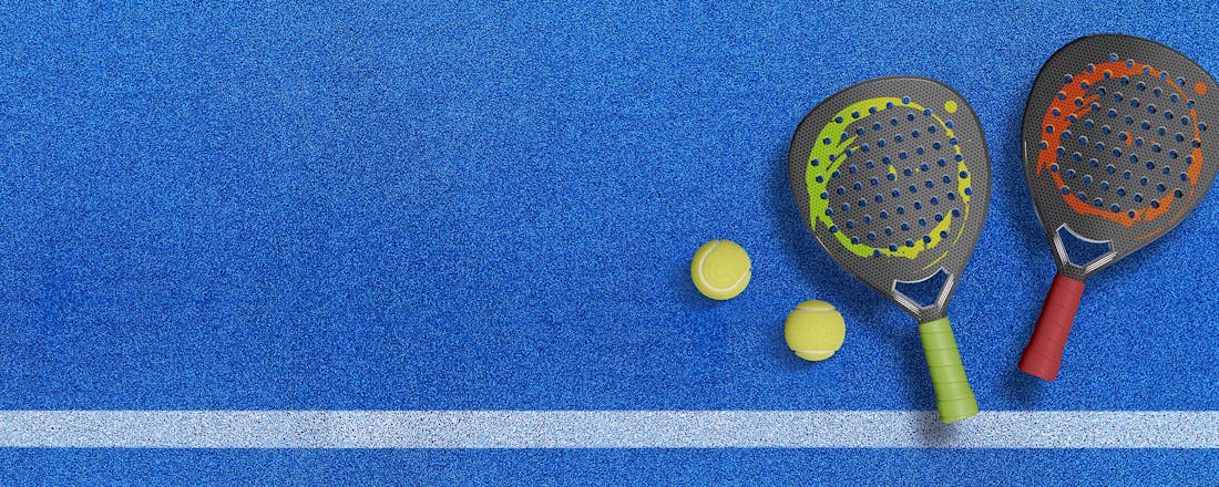 Padel rackets op een blauw gravelterrein Vijf nieuwe sporten om mee af te vallen