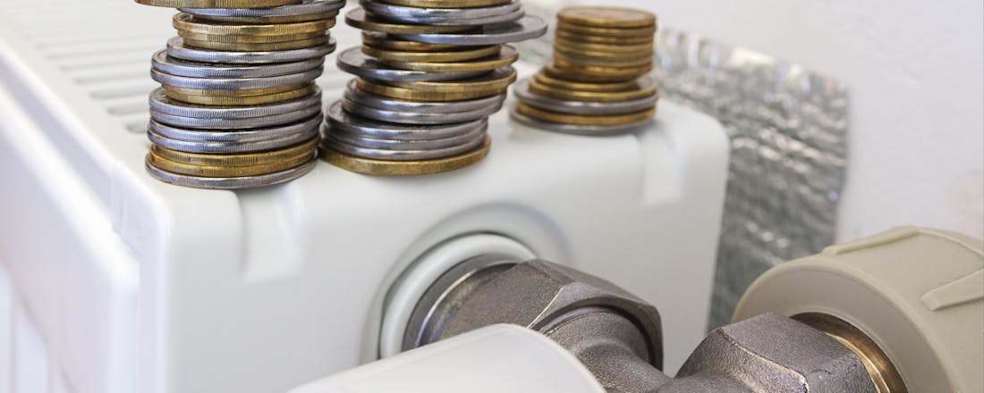 Radiator met radiatorfolie erachter en munten bovenop Meer warmte voor minder geld? Dit moet je weten over radiatorfolie