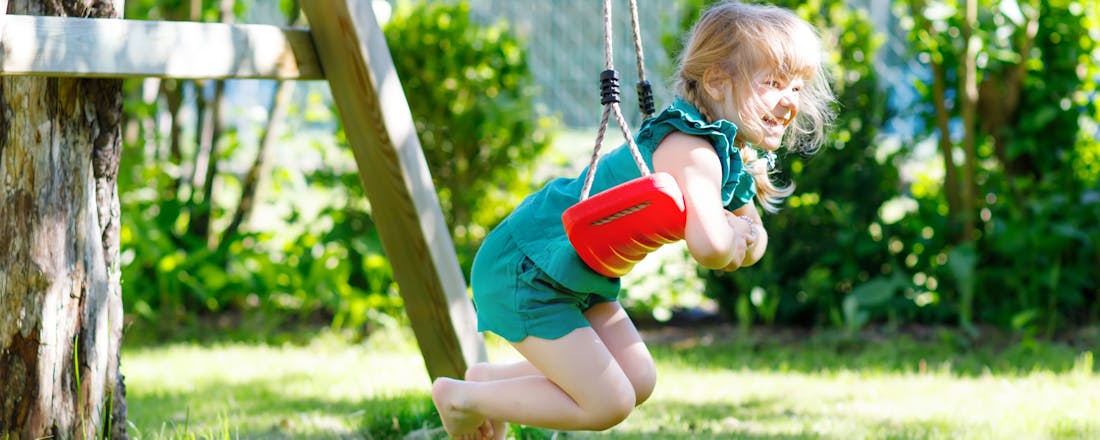 Meisje op een schommel in een tuin Maak van je tuin een speelparadijs (én ook nog leuk voor jezelf!)