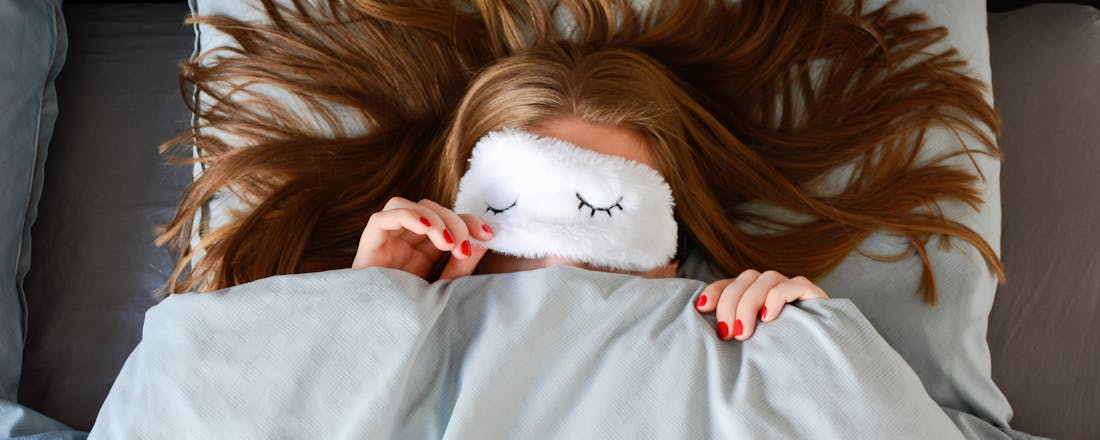 Vrouw met slaapmasker Wat gebeurt er tijdens je slaap? De 4 fases van de slaapcyclus uitgelegd