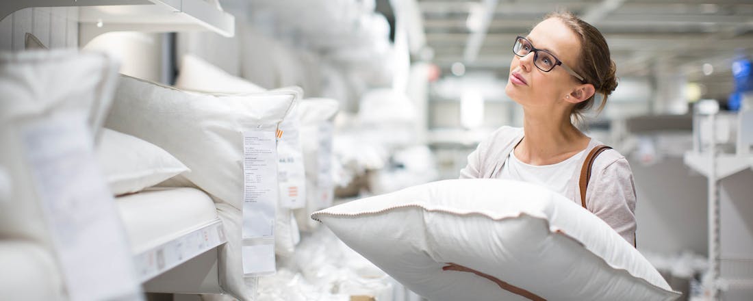 Vrouw die hoofdkussens vergelijkt in de winkel Daáág, slechte nachten! 10 tips om beter te slapen