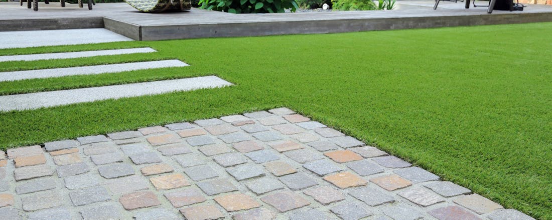 Tuin met tegels en kunstgras Kunstgras of echt gras: wat past beter bij mij?