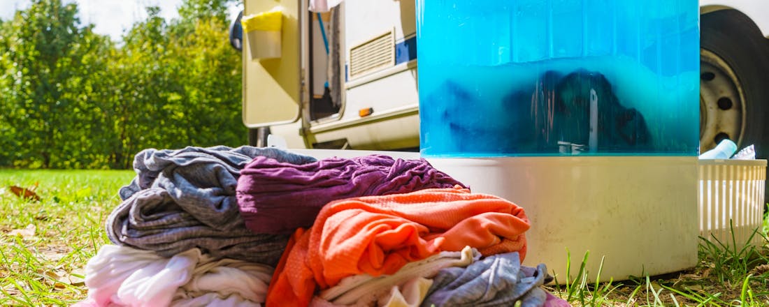 Wasmachine met wasgoed op de camping Met je campingwasmachine schoon en fris de vakantie door