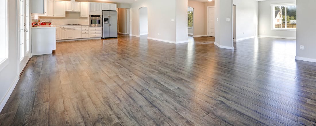 Laminaatvloer in lege woonkamer keuken Laminaat leggen voor beginners: tips en tools voor een strakke vloer