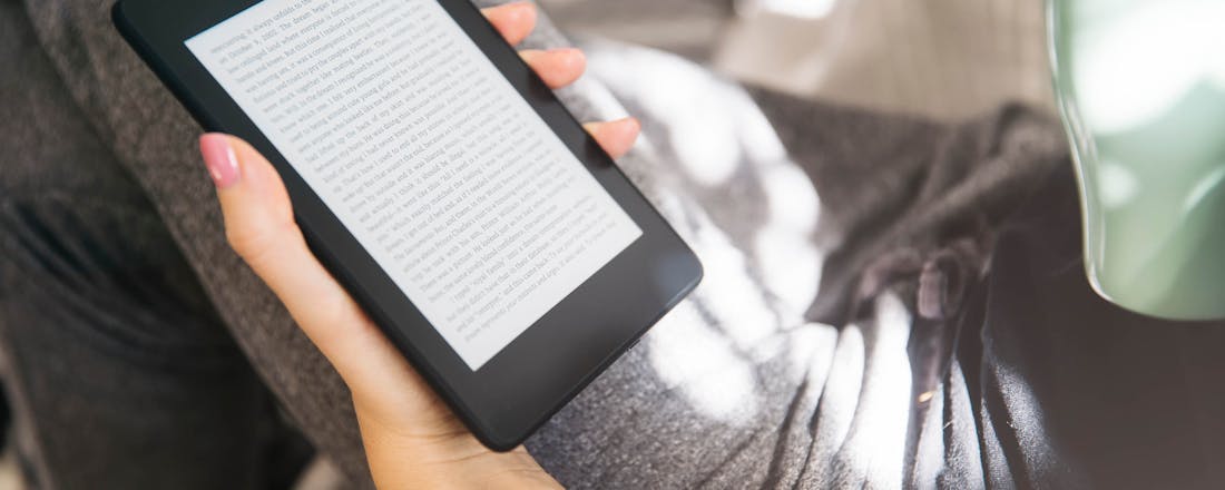 Vrouw leest op e-reader Kindle, Kobo of Tolino: welke e-reader past het best bij jou?