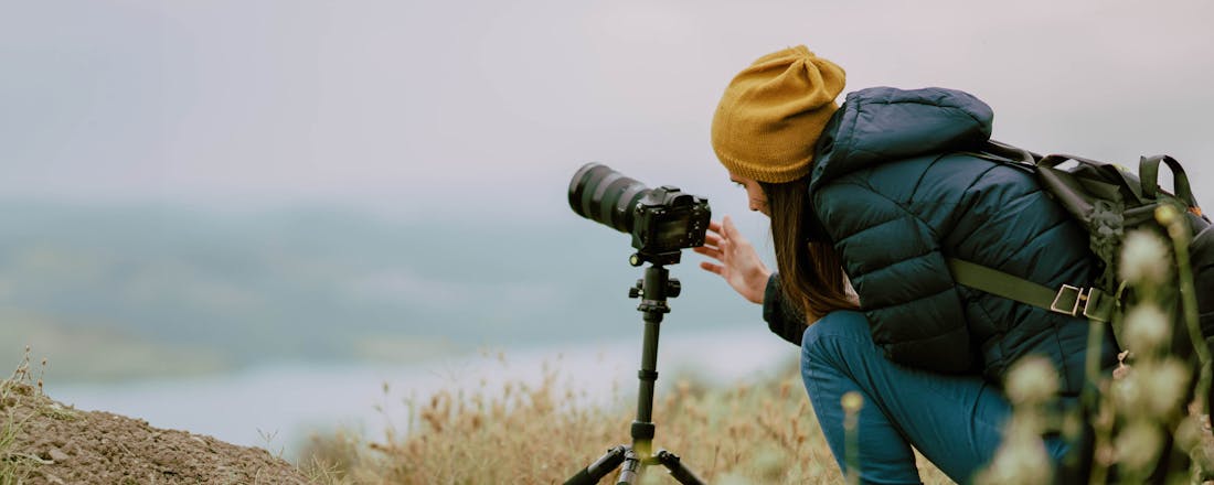 Vrouw fotografeert landschap Systeemcamera of spiegelreflex: welke past het best bij jou?