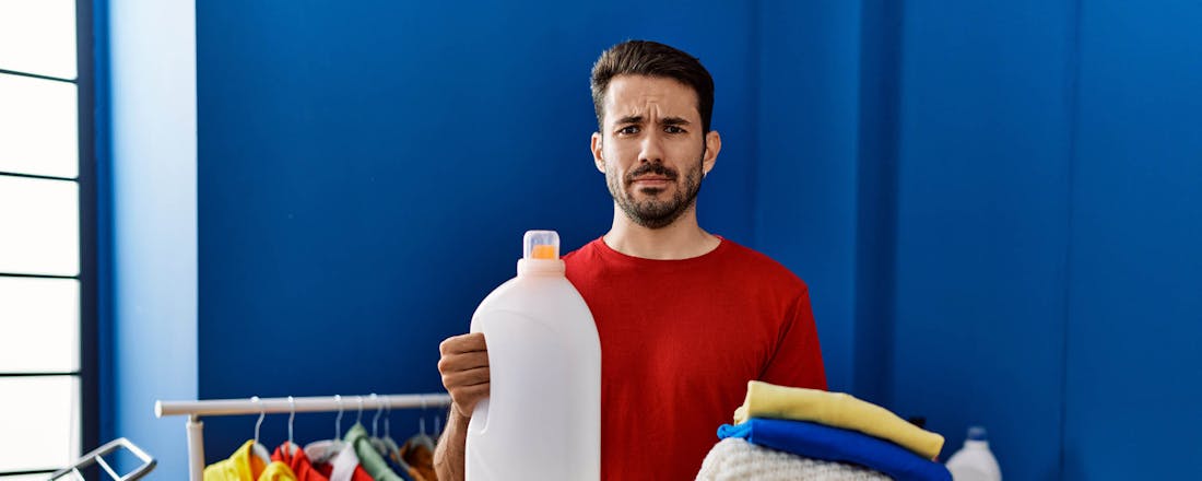 Man met lege wasmiddelfles Wasmiddel op? Zo krijg je je was toch schoon!