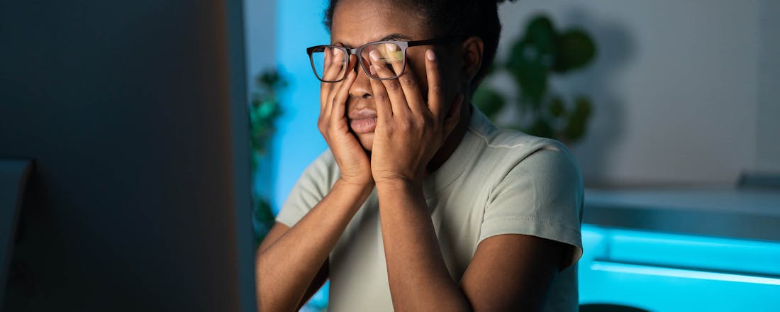 Vrouw die naar beeldscherm staart en in haar ogen wrijft Hoe schadelijk is blauw licht voor je gezondheid?