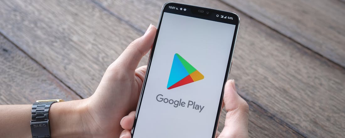 Man houdt telefoon vast met Google Play Google Play updatet apps niet automatisch, en nu?