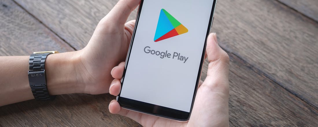 Man houdt telefoon vast met Google Play Malafide apps op Android? Zo ontwijk je ze!