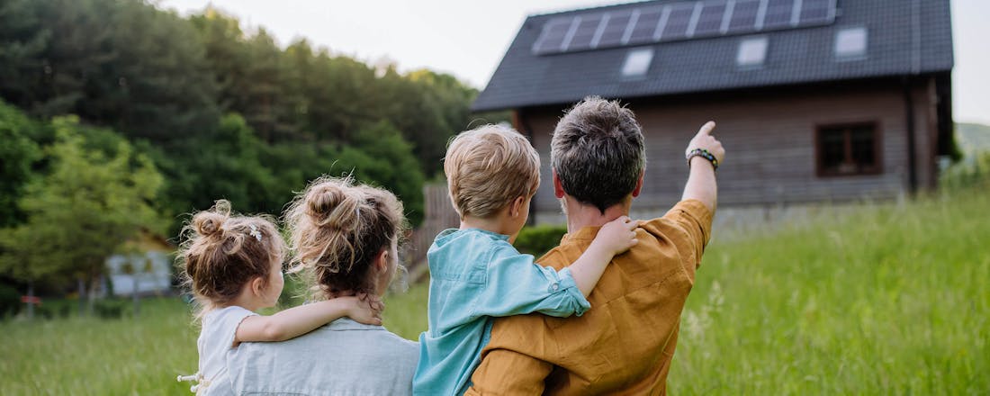 Gezin dat wijst naar huis met zonnepanelen op het dak ☀️ Verhuizen naar een huis mét zonnepanelen? Hier moet je op letten