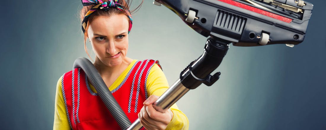 Huisvrouw die boos naar haar stofzuiger kijkt Je stofzuiger onderhouden: dit moet je weten