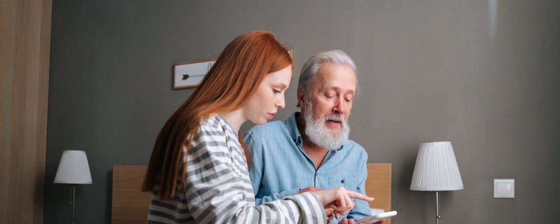 Oudere man en meisje samen op de smartphone 4 handige apps voor mensen met dementie en hun dierbaren