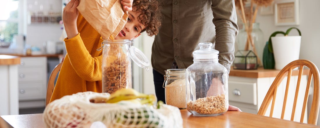 Kind helpt papa met pasta in een pot doen Zero waste huishouden: dit kun je zelf doen om minder weg te gooien