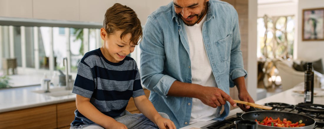 Vader en zoon zijn aan het koken Energiezuinig koken: 6 tips om je rekening te verlagen zonder in te leveren op smaak