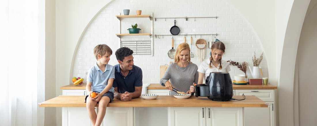 Familie bij arifryer in keuken Zo vind je de beste airfryer voor 4 personen