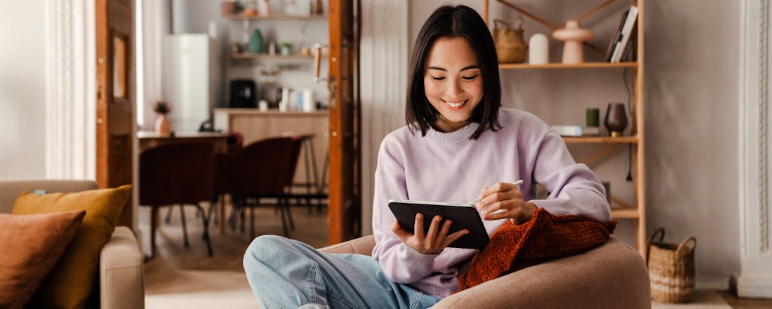 Vrouw op een stoel met een tablet in haar hand De 5 beste alternatieven voor de Google Play Store