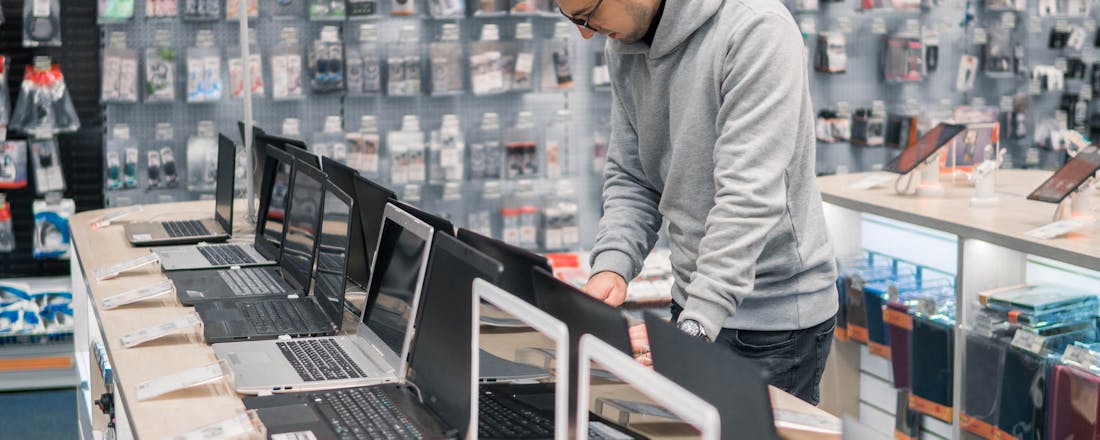 Man in laptopwinkel Je nieuwe laptop: wordt het Windows, MacOS of toch ChromeOS?