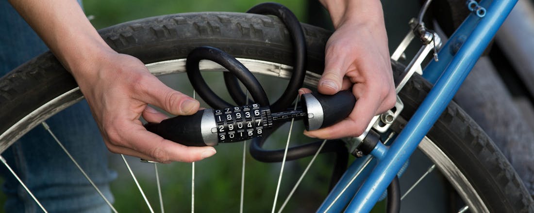 Man die fiets op slot zet met cijferslot Het kiezen van het juiste kabelslot voor jouw fiets